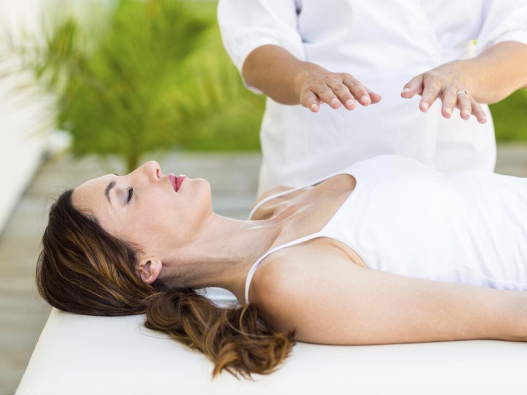 Calm woman receiving reiki treatment